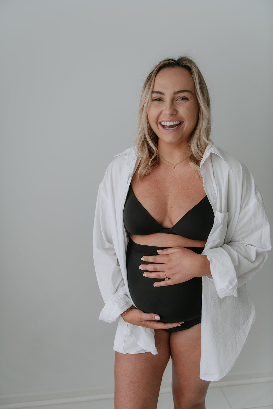 Pregnant model wearing Mummy Undies maternity underwear under casual shirt, showing everyday comfort.