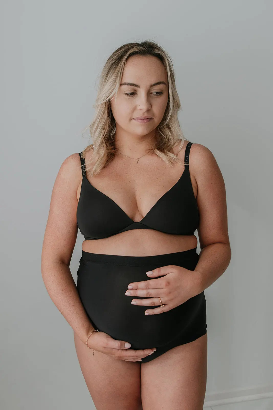 Front-facing pregnant model wearing Mummy Undies maternity underwear, supporting baby bump and ideal for postpartum comfort.